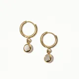 Aros dorados tipo argolla con dije colgante redondo de nácar.