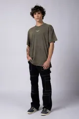 Remera de corte holgado con efecto de lavado ácido en tono gris oscuro. Presenta un pequeño estampado gráfico en el centro del pecho con la inscripción 'ASTRAL ENERGY' y las siglas 'VCP'.