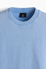 Remera de algodón de punto liviano, color celeste, con corte oversized, hombros caídos, cuello redondo acanalado y mangas cortas.