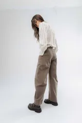 Jean wide leg color marrón, con corte recto y amplio, y costuras protagonistas que crean un diseño geométrico en las piernas.