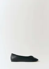 Zapato tipo bailarina de cuero vacuno color negro, con punta redonda y detalle de lazo decorativo en la parte frontal.