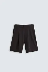 Bermuda negra de corte ancho (wide fit) confeccionada en tejido con mezcla de viscosa. Presenta pliegues en el delantero, bolsillos frontales y bolsillos de vivo en la parte trasera. Cierre frontal con cremallera y gancho metálico oculto.