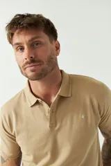 Remera polo blanca de manga corta, con cuello clásico, cierre de tres botones y logo estampado en el pecho.