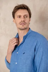 Camisa de lino color beige con cuello mao, corte slim fit y mangas 3/4 con botón para sujetar.