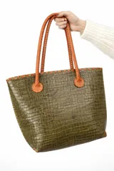 Bolso shopper de cuero azul con textura crocco, manijas largas marrones y costuras artesanales visibles en los bordes.