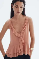 Musculosa color salmón con escote en V pronunciado, breteles anchos y detalle de volados en el escote y en el bajo de doble capa.