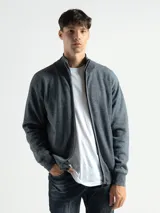 Campera de punto Osaka color gris melange, con cuello alto, cierre frontal metálico y bolsillos laterales. Cuenta con interior de polar.