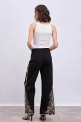 Musculosa de tejido de punto acanalado, color negro, con cuello halter y ajuste al cuerpo.