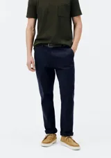 Pantalón de vestir color verde oscuro, de corte slim, con bolsillos laterales y traseros. Se ajusta a la cintura con botón y cierre.