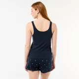 Pijama corto de dos piezas en color azul marino, compuesto por una musculosa lisa con un pequeño corazón rojo bordado en el pecho y un short con estampado de corazones blancos y elástico en la cintura.