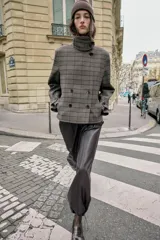 Pantalón de tiro alto confeccionado en material con efecto piel, con cintura elástica, bolsillos delanteros y nervio marcado en el frente. Presenta un diseño bombacho con bajo ajustable mediante cordones elásticos.