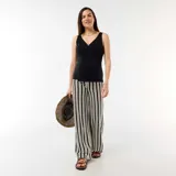 Pantalón de maternidad de corte recto y tiro alto, con estampado de rayas verticales en blanco y negro. Presenta cintura elástica diseñada para adaptarse al crecimiento de la panza durante el embarazo.