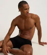 Calzoncillo tipo boxer de microfibra color negro, con cintura elástica que presenta detalle de líneas horizontales y logo de la marca.