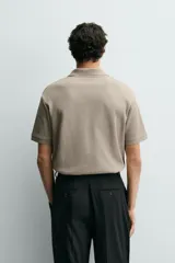 Polo regular fit color verde militar con textura acanalada vertical, cuello solapa con abertura frontal, manga corta y acabados en rib.