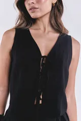 Chaleco negro con escote en V y lazo de ajuste frontal.