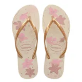 Sandalias tipo ojotas Havaianas modelo Slim Organic, con base color crema estampada con flores en tonos rosados y tiras finas metálicas en color dorado.
