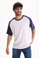 Remera oversize de manga corta raglán, color blanco con mangas y cuello en azul marino.