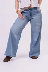 Pantalón wide leg de denim rígido, de tiro bajo en color celeste claro con sutiles desgastes, pernera ultra ancha y diseño de cinco bolsillos.