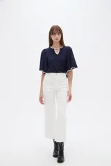Pantalón jean blanco de corte recto y tiro alto con terminación deshilachada en el Isodelo.