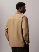 Sobrecamisa de algodón Calvin Klein con relleno ligero, diseño de corte regular, cierre frontal con botones a presión, bolsillos frontales con solapa y puños abotonados.