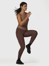 Calza deportiva de tiro alto en color marrón chocolate, confeccionada en tejido suave con tecnología de Aloe Vera para mayor confort. Presenta un diseño ajustado que favorece la libertad de movimiento.