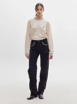Pantalón de tiro medio confeccionado en pana negra, de corte holgado y diseño recto, con detalle de línea lateral en tono contrastante.