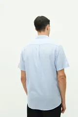 Camisa de manga corta confeccionada en una mezcla de lino y algodón, con cuello clásico, cierre frontal de botones y bolsillo en el pecho con logo bordado.