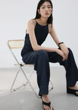 Mono largo de denim color azul oscuro, con escote halter y diseño recto en las piernas.