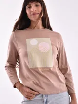 Remera de manga larga color beige, con cuello redondo y estampado frontal que dice "Magic is something you make" en color lila.