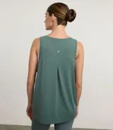 Musculosa deportiva de mujer marca Get Over, confeccionada en tejido de poliamida con elastano. Presenta escote redondo, sisas amplias y un diseño holgado con recorte horizontal en la espalda que incluye un pliegue central para mayor libertad de movimiento.