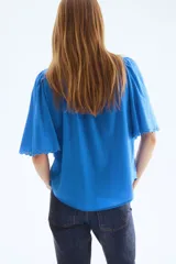 Blusa oversized azul de mezcla de algodón y viscosa, con cuello mao, botonadura frontal y mangas cortas abullonadas con terminación de broderie.