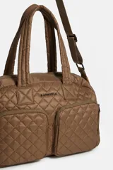 Cartera Rapsodia tipo morral acolchado color marrón con costuras romboidales, doble asa de mano y correa larga ajustable. Cuenta con dos bolsillos frontales con cierre y llavero colgante con pompones.