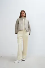 Campera de diseño estructurado con cuerpo en lana tejida y mangas en tejido de punto grueso. Presenta cuello alto, cierre frontal con botones ocultos y bolsillos frontales con doble abertura.