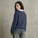 Jean de corte wide leg con tiro medio, confeccionado en denim de tono azul lavado con efecto desgastado.