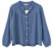 Camisa de lino color azul jean, con mangas largas abullonadas y puños elásticos. Presenta escote en V con cuello mao y cierre frontal con botones claros.