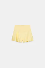 Shorts de tiro medio confeccionados en tejido satinado color amarillo con estampado de lunares blancos y bajo con vuelo.