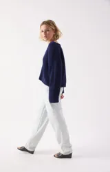 Sweater de punto fino color azul marino, con cuello redondo amplio y mangas largas con puños rectos. Presenta un corte holgado y diseño minimalista.