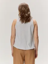 Musculosa de algodón color azul marino, con escote en V y un bordado artesanal de flor en el frente con contorno naranja y relleno dorado.