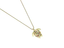 Cadena de eslabones finos con dije en forma de tortuga, con acabado dorado y detalles de circonias multicolor incrustadas en el caparazón.