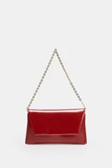 Bolso tipo bandolera de diseño estructurado, acabado brillante en color rojo y correa de cadena dorada. Cuenta con solapa frontal y doble compartimento interior.