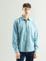 Camisa celeste de manga larga confeccionada en algodón, de corte clásico y con bolsillo en el lado izquierdo del pecho.