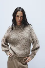 Jersey de punto con textura peluda, cuello redondo y mangas largas abullonadas con puños ajustados.
