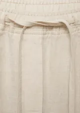 Pantalon de lino color beige, de corte recto y tiro alto. Cuenta con cintura elástica con cordón ajustable y bolsillos laterales.