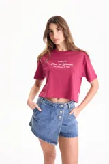 Remera crop de algodón color bordó, con mangas cortas, cuello redondo y estampa frontal con texto en color blanco.