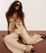 Pantalón texturizado marrón de corte ancho con cintura elástica y bolsillos laterales.