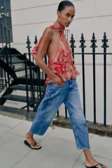 Top rojo con estampado estilo paisley, diseño de cuello halter con lazo, espalda descubierta y detalles de volantes en capas en el frente.