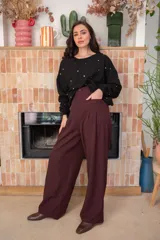 Sweater de corte oversize color beige, confeccionado en algodón. Presenta un diseño holgado con cuello redondo, puños y ruedo acanalados, decorado con múltiples apliques metálicos circulares en tonos dorados y plateados distribuidos por toda la prenda.