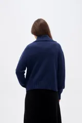 Cardigan de punto con diseño de ochos, color azul marino, con cuello solapa, cierre frontal con botones y mangas largas con puños acanalados.
