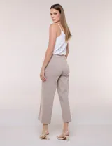 Pantalón crop blanco de corte recto con cintura ancha y botones decorativos laterales. Cuenta con bolsillos y pinzas frontales.