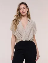 Blusa crop cruzada Allie Rose de rayón y poliéster, color beige con estampa de lunares negros. Tiene escote en V con cuello camisero, frente cruzado y mangas cortas amplias.